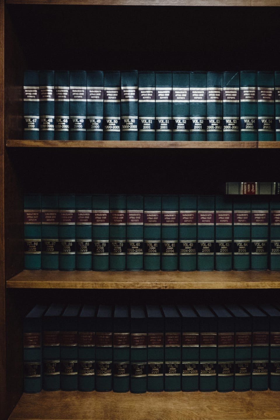 Wooden bookshelves filled with rows of law books.